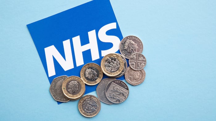 NHS logo with British coins