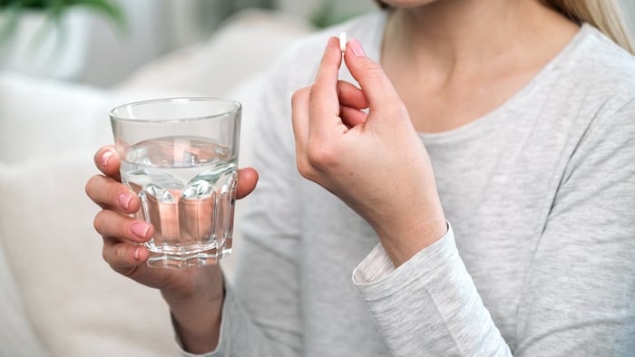 Woman taking pill with water