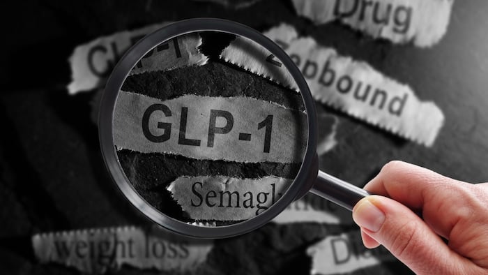 Magnifying glass over GLP-1 on blackboard