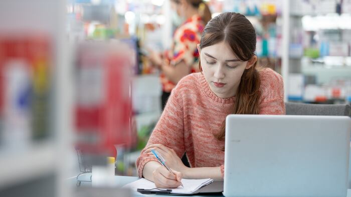 Person writing/studying in pharmacy