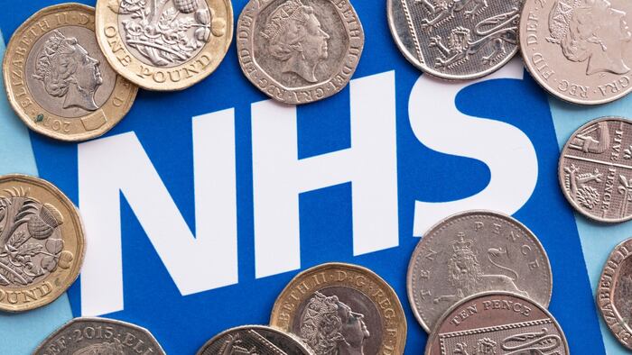 Logo of UK's NHS, National Health Service, surrounded by coins (pounds and pence)