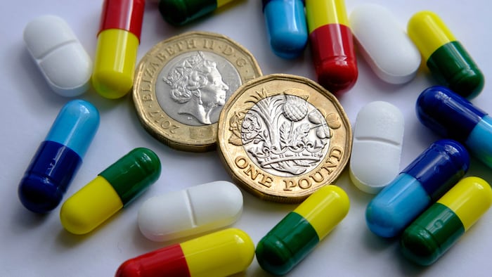 Pile Of Different Pills Placed Around Two British Pound