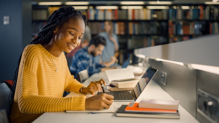 student working on a laptop in a library
