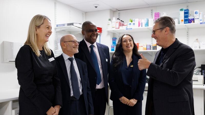 The prime minister Keir Starmer gives a thumbs up to four Boots staff members in a pharmacy