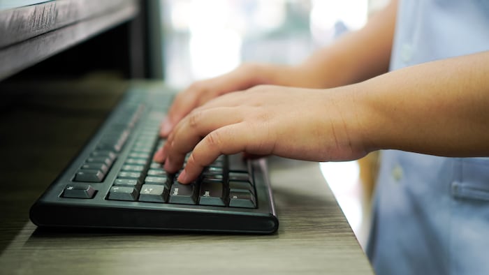 Pharmacist typing on computer keyboard
