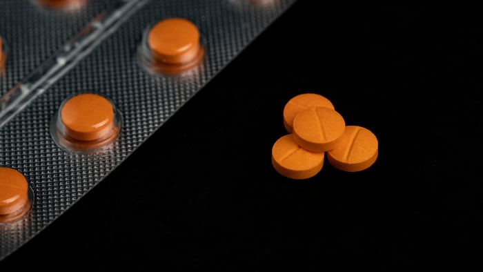 Orange pills on black background