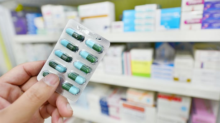 Pharmacist holding blister pack of pills