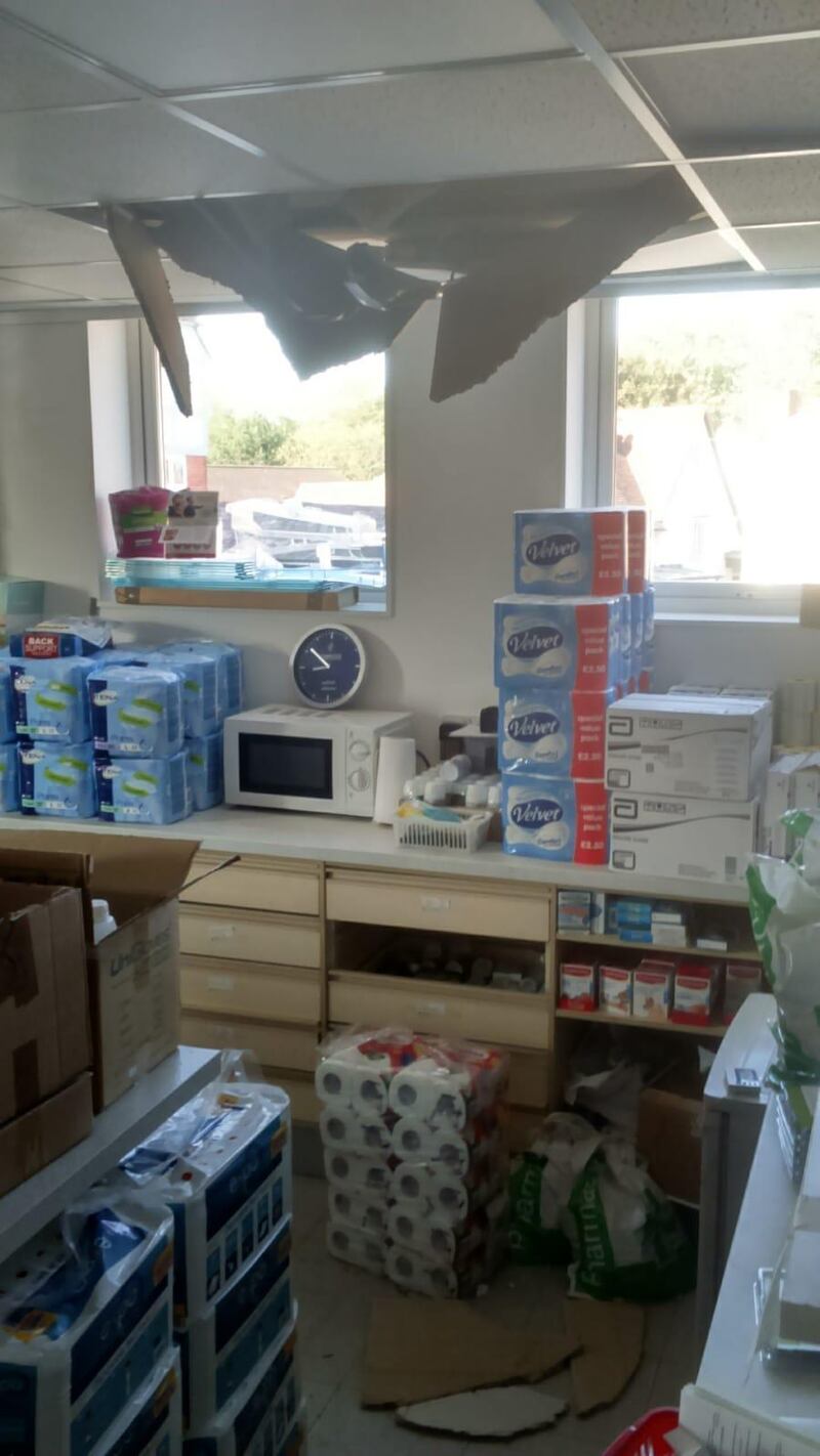 a hole in a ceiling above a pharmacy counter and a window