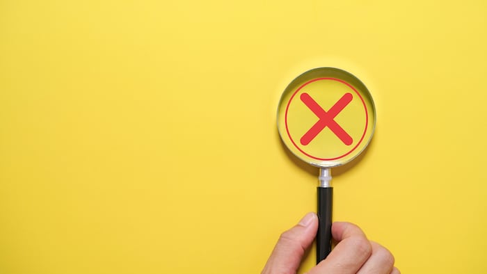 Magnifying glass with a red cross inside