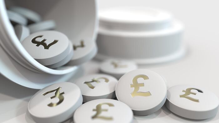 Close-up shot of pills with stamped pound sterling GBP symbol on them