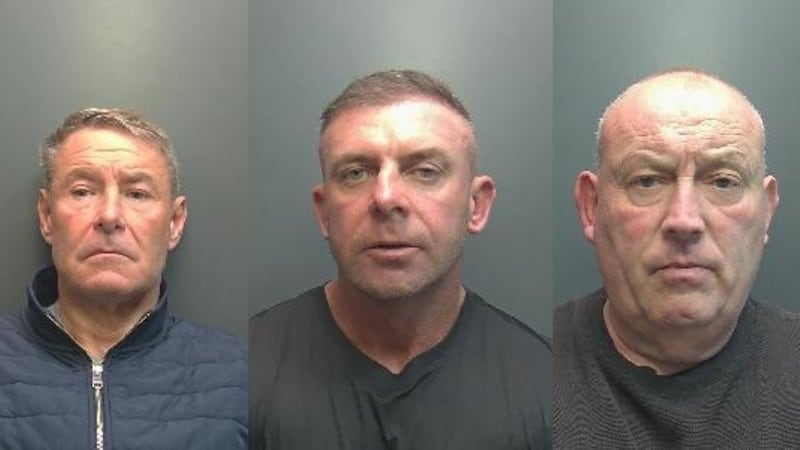 Three white men look at the camera in a mugshot. The left man wears a blue jacket with short hair. The middle man wears a grey t-shirt with short hair. The right man is bald and wears a grey t-shirt.