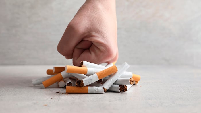 fist pushing down on cigarettes