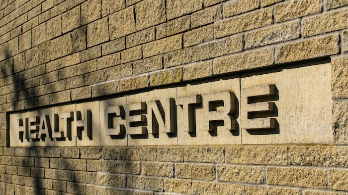 the words health centre in stone on a brick wall