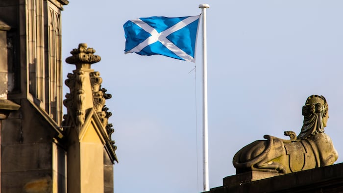 scottish flag in the sky in between buildings
