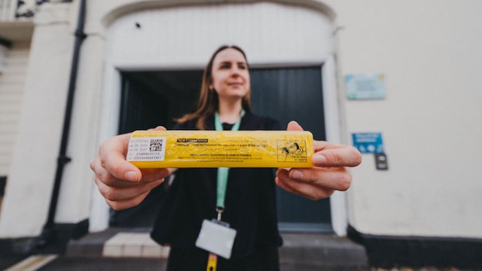 A woman holds an injection of naloxone