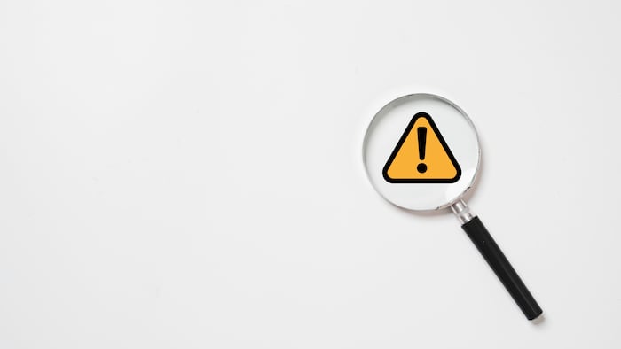 Magnifying glass with warning sign