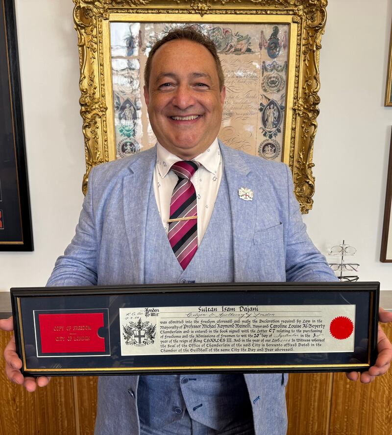 A man holding a plaque celebrating him being a freeman of london