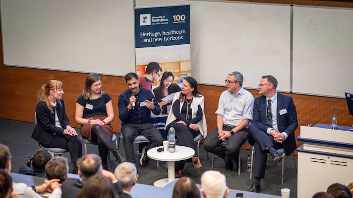 a group of six people talk on a panel discussion