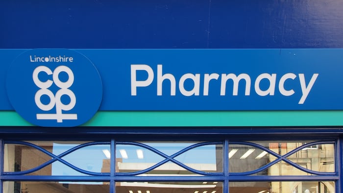 A blue sign says pharmacy next to a logo that says Lincolnshire Coop